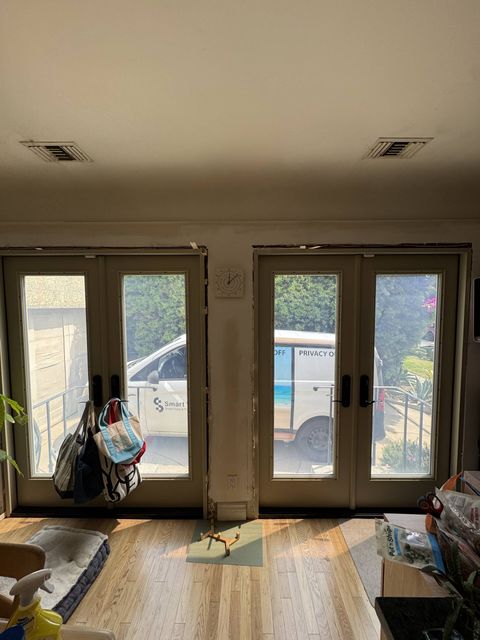 Two sets of French doors with switchable film in clear mode in a Los Angeles home, the Smart View install van parked outside