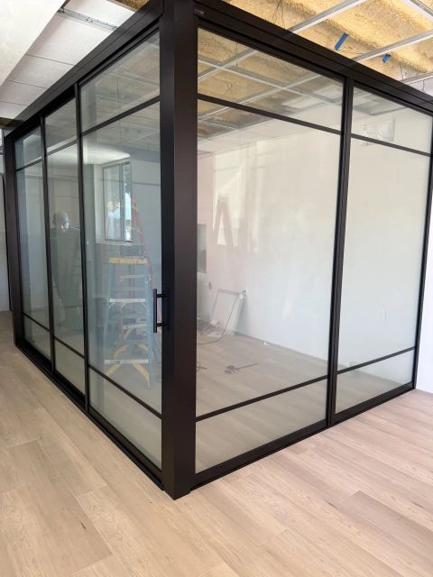 Smart glass meeting room in Santa Barbara CA with black metal frame and switchable privacy glass