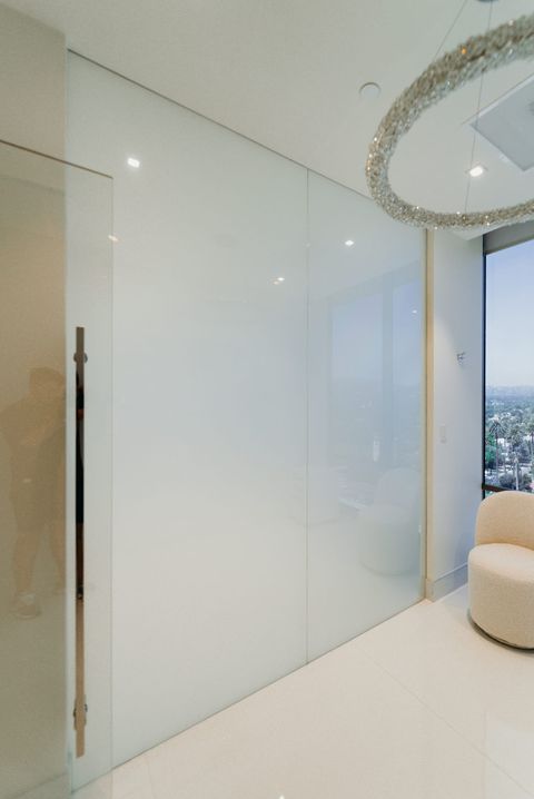Frosted switchable privacy glass beside a clear floor-to-ceiling window with a city view in a Beverly Hills suite