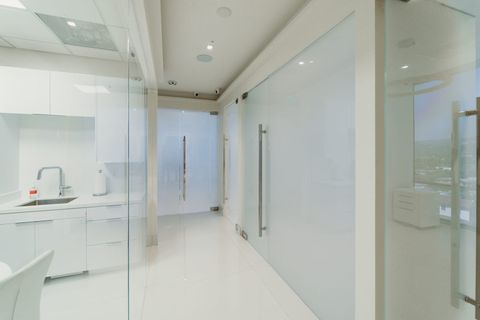 A run of frosted switchable smart glass partitions along a corridor in a Beverly Hills professional suite