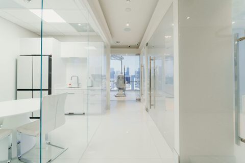 Switchable smart glass partitions in a Beverly Hills high-rise suite, frosted for privacy with the city skyline visible beyond