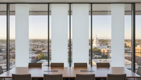 Downtown Sacramento boardroom with a floor-to-ceiling switchable smart glass wall — alternating panels clear over the Capitol dome and the valley skyline, the rest switched to flat, evenly frosted milky-white privacy