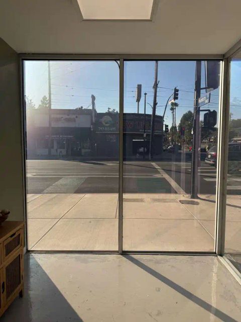 Smart glass storefront windows in Reseda CA switched to clear mode showing street view