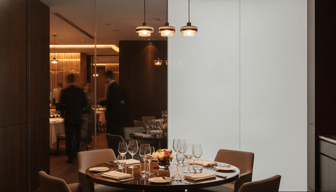 Illustration: a restaurant private dining room behind a smart glass partition — one half clear to the main floor, the other switched to frosted privacy
