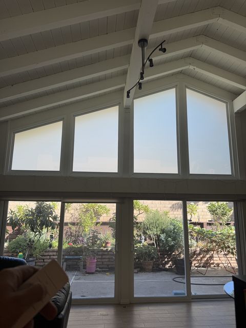 Hand holding the remote as all four Irvine gable windows switch to frosted privacy white