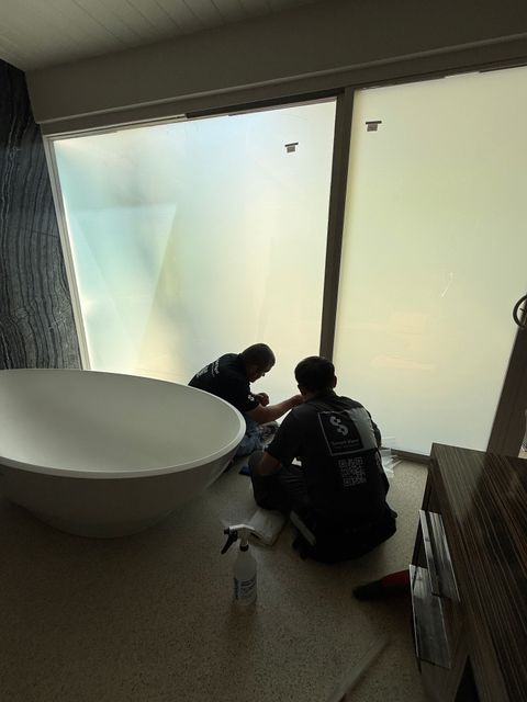 Smart View installers finishing frosted smart film on the Palm Springs bathroom courtyard glass