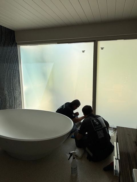 Palm Springs bathroom with freestanding tub, courtyard glass frosted by smart film during installation
