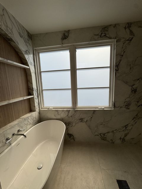 The same Hermosa Beach bathroom glass switched to a flat milky-white frost for privacy on one switch