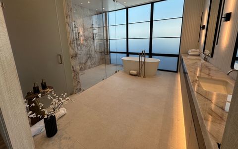 Smart glass bathroom window in Newport Beach frosted for privacy, freestanding tub under the black steel window wall