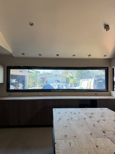 Long horizontal letterbox kitchen window in Seal Beach powered clear, showing the street beyond the switchable film