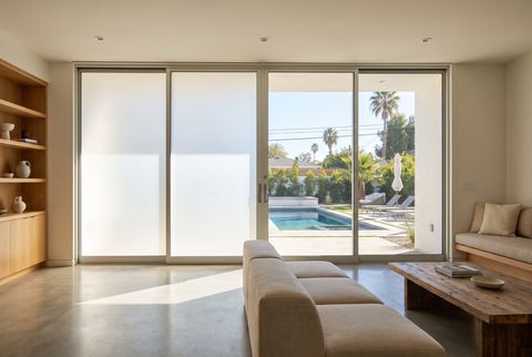 Illustration: a diagram of a two-panel sliding patio door with one panel clear and one panel frosted, showing the low-voltage leads exiting the glass edge in a service loop and routing along the frame into the jamb