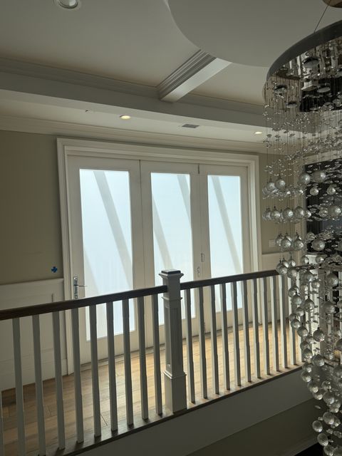 Studio City landing bifold door with the smart glass frosted, all three panels milky white and the pergola rafters as soft diagonal bands