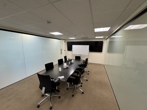 Corner boardroom in a Thousand Oaks office, frameless glass walls frosted by smart film for a private meeting