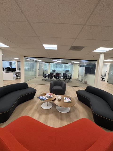 Lobby lounge in a Thousand Oaks office looking at a clear smart film glass conference room wall