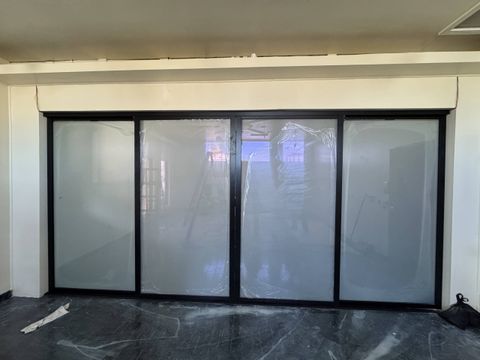 PDLC switchable smart glass film integrated into three sliding conference-room doors at a Gardena office — frosted state for meeting privacy