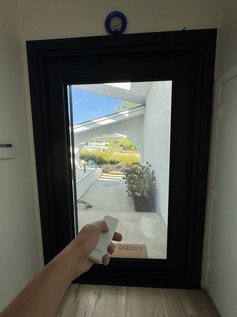 Remote in hand, the Topanga door glass clear with the courtyard beyond