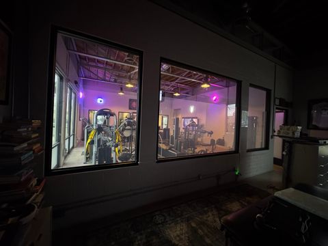Clear switchable smart film on the interior windows of a Ventura gym, the workout floor visible through the glass