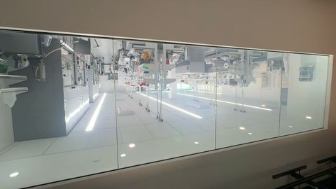 Corridor view through a laboratory observation window fitted with switchable smart film