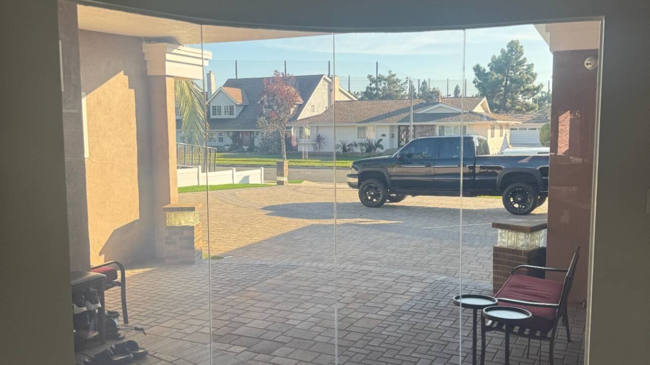 Luxury smart glass for homes — clear-mode curved floor-to-ceiling smart glass wall in a high-end Beverly Hills residential space designed for luxury privacy spec